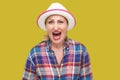 Portrait of angry or shocked modern stylish mature woman in casual style with white hat standing and looking at camera and Royalty Free Stock Photo