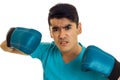 Portrait of angry sportsman in blue gloves and uniform practicing boxing on camera isolated on white background Royalty Free Stock Photo