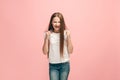 Portrait of angry teen girl on a pink studio background Royalty Free Stock Photo