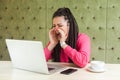 Portrait of angry upset young dissatisfied businesswoman with black dreadlocks hairstyle in pink blouse sitting in and screaming