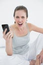 Portrait of an angry woman shouting with mobile phone in hand Royalty Free Stock Photo