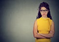 Portrait of angry woman in yellow dress standing with arms folded Royalty Free Stock Photo