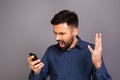 Portrait of angry young man screaming on his mobile phone Royalty Free Stock Photo