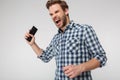 Portrait of angry young man screaming and holding cellphone Royalty Free Stock Photo