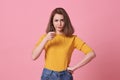 Portrait of angry young woman pointing finger at camera over pink background Royalty Free Stock Photo