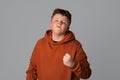 Portrait of annoyed angry plus size teenager boy shaking fist, standing over gray isolated background, looking at the camera Royalty Free Stock Photo