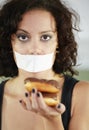 Portrait, anorexia and woman with donut and tape over mouth to stop eating, unhappy and delusional. Face, covering and