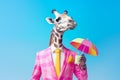 portrait of a Anthropomorphic cute giraffe in a pink suit and glasses with a cocktail in his hands on the beach against the sky.