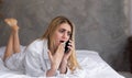 Portrait of an anxious young girl talking on the phone hears bad news with disgusting emotions on her face. Royalty Free Stock Photo