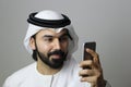 Portrait Of An Arab Male Model Using Mobile And Wearing UAE Emirati Traditional Dress ARAB MODEL BUSINESS MOBILE