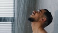 Portrait Arab Spaniard Indian young handsome manly wet man bearded brunette guy washes in shower enjoys falling water Royalty Free Stock Photo