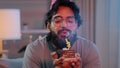 Portrait arabian happy indian male face bearded man wears festive birthday pink hat and glasses holds cupcake makes wish