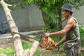 Portrait of arborist cutting the log by chainsaw machine with sawdust splash around. Motion blurred of sawing chainsaw