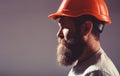 Portrait architect builder, civil engineer working. Builder in hard hat, foreman or repairman in the helmet. Bearded man