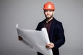 Portrait of an architect builder studying layout plan of the rooms, serious civil engineer working with documents on construction Royalty Free Stock Photo