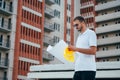 Portrait of an architect builder studying layout plan of the rooms, serious civil engineer working with documents on construction Royalty Free Stock Photo