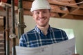 Portrait Of Architect Inside House Being Renovated Studying Plans