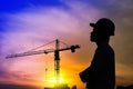 Portrait of architect silhouette wear a helmet at construction site with crane background and sunset Royalty Free Stock Photo