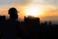 Portrait of architect silhouette wear a helmet at construction site with crane background and sunset Royalty Free Stock Photo