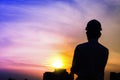 Portrait of architect silhouette wear a helmet at construction site with crane background and sunset Royalty Free Stock Photo