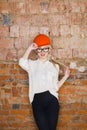 Portrait of architect student or painter with blueprints protect helmet wearing. Brick red background. Royalty Free Stock Photo