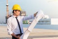 Portrait of architect wear yellow safety helmet and verify the blueprint with commitment on construction site with crane Royalty Free Stock Photo