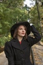 Portrait of aristocratic woman in black hat with veil looking up, in autumn park. Middle-aged woman in vintage retro style Royalty Free Stock Photo