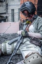 Portrait of army girl with rifle in camouflage clothes in urban scene, in hiding