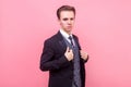 Portrait of arrogant young businessman in expensive suit looking supercilious and self-confident. indoor studio shot isolated on Royalty Free Stock Photo