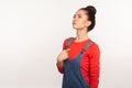 Portrait of arrogant egoistic girl with hair bun in denim overalls pointing herself and looking up with proud self-confident Royalty Free Stock Photo