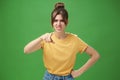 Portrait of arrogant impolite young woman in yellow t-shirt pointing at camera squinting and grimacing from disdain and