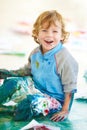 Portrait, art and a boy painting on the floor of a studio for creative expression or education at school. Smile, paint