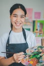 Portrait of Art student smiling happily while with watercolor painting on canvas doing some art projects on studio workshop