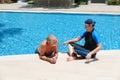 Portrait asia senior woman and caucasian old man resting together in the edge of swimming pool in clubhouse Royalty Free Stock Photo