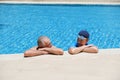 Portrait asia senior woman and caucasian old man resting together in the edge of swimming pool in clubhouse Royalty Free Stock Photo