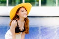 portrait asia sexy woman at swimming pool wearing black lingerie and white short with yellow sombrero hat, fashion in summer Royalty Free Stock Photo