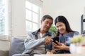 Portrait of Asian adorable senior couple using smartphone together video chatting with family in living room at home. Royalty Free Stock Photo