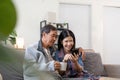 Portrait of Asian adorable senior couple using smartphone together video chatting with family in living room at home. Royalty Free Stock Photo