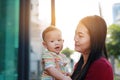 Portrait of Asian baby boy lying in hug of mother with looking camera Royalty Free Stock Photo