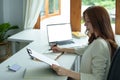 Portrait of an Asian bank employee using notebooks to take notes, budget documents and computers to close financial