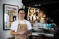 Portrait of asian barista holding digital tablet at counter in c Royalty Free Stock Photo