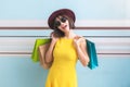 Portrait of asian beautiful girl wearing yellow dress and sunglasses holding shopping bags Royalty Free Stock Photo