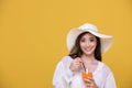 Portrait Asian beautiful happy young woman with hat smiling cheerful and Holding a glass of orange juice in summer and looking at Royalty Free Stock Photo