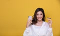 Portrait Asian beautiful happy young woman smiling cheerful and she is holding credit card and using smart phone for shopping Royalty Free Stock Photo