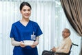 Portrait of Asian beautiful woman nurse at nursing home hold food bowl to serve disabled senior elderly man on wheelchair. Therapi Royalty Free Stock Photo