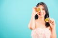 Portrait asian beautiful woman smiling her holding halves of orange on face near eyes Royalty Free Stock Photo