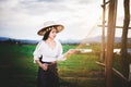 Asian Beautiful woman in Thai local dress working with fishing net in fishing village with field and lake background Royalty Free Stock Photo