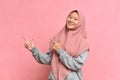 Portrait of Asian beautiful young muslim woman pointing both hands with finger on upper side with smile face Royalty Free Stock Photo