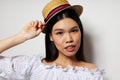 Portrait Asian beautiful young woman hat in hand posing smile isolated background unaltered Royalty Free Stock Photo