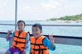Portrait of Asian boy and girl on boat at the beach Royalty Free Stock Photo
